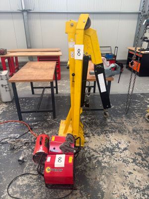 une photo d'une grue dans un atelier, avec des outils