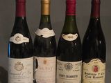 quatre bouteilles de vin sont alignées sur une table