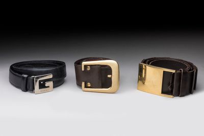 three leather belts with gold buckles on a white background