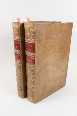 deux vieux livres posés l'un sur l'autre sur une surface blanche