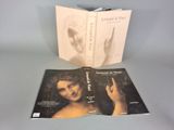 Le livre est ouvert et laisse apparaître la photo du visage et des mains d'une femme.