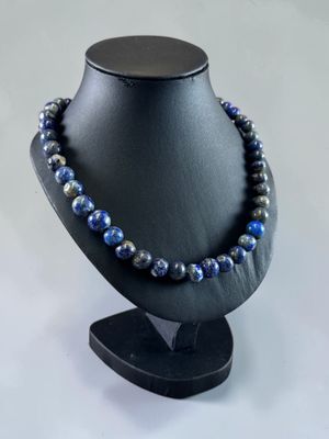 a black mannequin with a blue beaded necklace on it