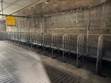 a long row of beds in a building with a yellow sign