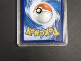 the pokemon card is in a plastic case on a table