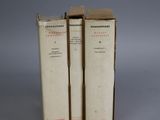 three books are stacked on top of each other on a gray surface