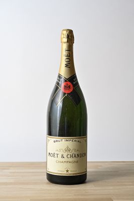 moet and chandon champagne bottle on wooden table against white wall