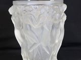 a glass vase that is sitting on a black surface