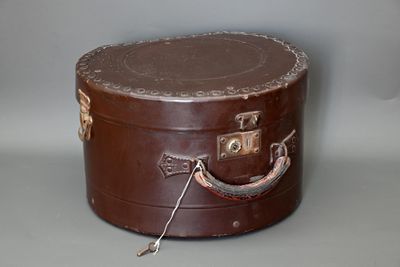 une valise marron posée sur une table, avec une poignée