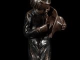 bronze statue of a boy holding a hat and looking down