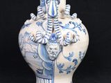 a blue and white vase with a handle on a black background