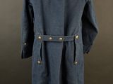 the back view of a blue coat on a mannequin stand