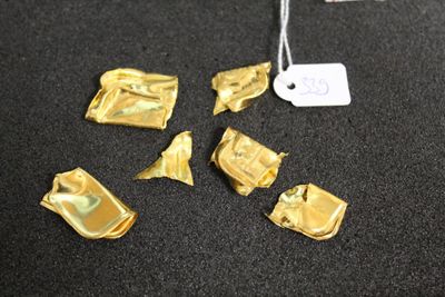 plusieurs morceaux de feuille d'or posés sur une table noire