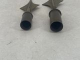 a pair of metal studs sitting on top of a white surface