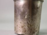 a silver cup that is sitting on a table