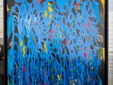 painting on a window sill of a blue and yellow abstract painting