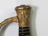 a close up of a gold and black sword with a handle