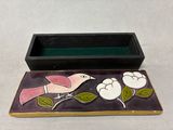 a small box with a bird on it sitting on a table