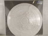 white decorative ceiling medallion in plastic package on white surface