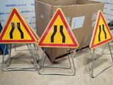 three road signs that are on a stand in front of a box