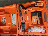 une mallette à outils orange, contenant des outils, posée par terre