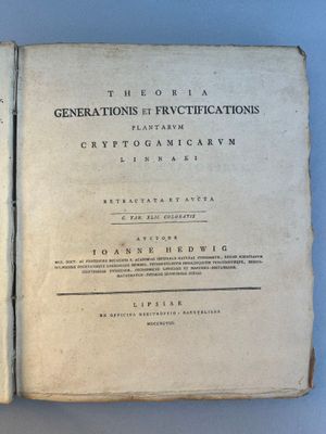 un vieux livre est ouvert sur une table, sur fond bleu