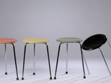 three different colored stools sitting next to each other on a white surface