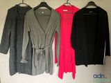three women ' s sweaters hanging on a wall in a row