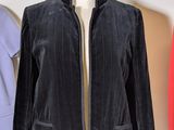 a black jacket on a mannequin stand next to a red jacket