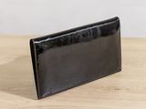 a black wallet sitting on top of a wooden table