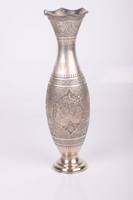a silver vase that is sitting on a white surface