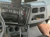 un homme au volant d'un camion, un téléphone portable à la main