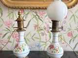 deux lampes posées sur une table devant un tableau