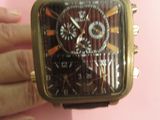 une personne tenant une montre à la main sur un fond rose