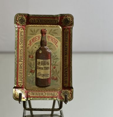 a miniature picture of a bottle of liquor on a miniature chair