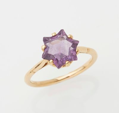 a gold ring with an amethorate stone in the center