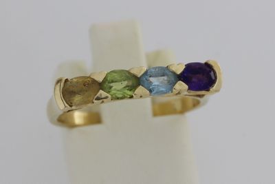 gros plan d'une bague en or avec trois pierres de couleurs différentes