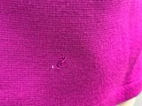 le dos d'un pull violet avec un petit trou au milieu
