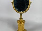 miroir plaqué or avec un verre bleu, posé sur un socle
