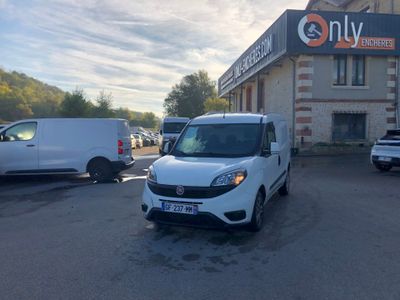 une photo d'une camionnette blanche garée devant un immeuble