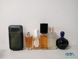 de nombreux flacons de parfum de toutes sortes alignés sur une étagère