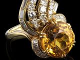 un gros plan d'une bague sertie d'un saphir jaune et de diamants blancs