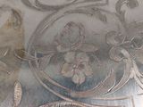 a close up of a silver plate with designs on it