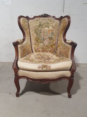 une vieille chaise dont l'assise est recouverte d'un tissu à motifs floraux