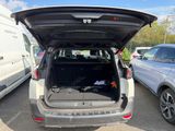 the back of a white van with its trunk open in a parking lot