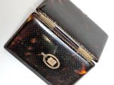 an image of a tortoise shell purse with a gold clasp