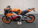 an orange and black motorcycle parked on a black and white checkered floor