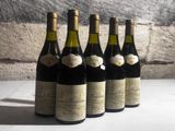 six bottles of wine are lined up on a table