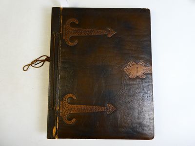 un carnet en cuir marron orné d'une ancre sur la couverture