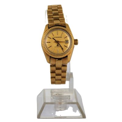 une photo d'une montre-bracelet en or posée sur un socle transparent