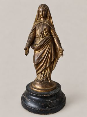 a bronze statue of a woman with a veil on her head